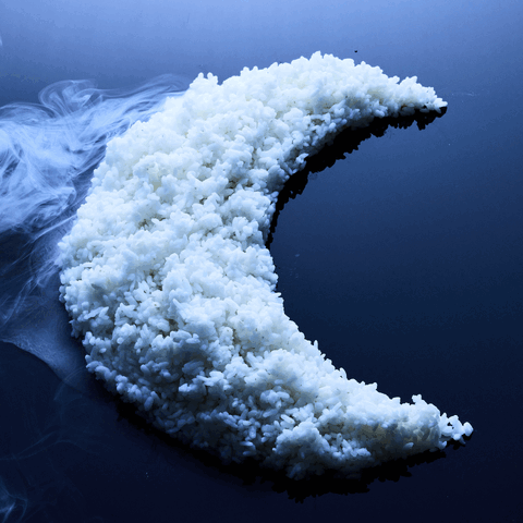 A crescent moon made of steamed rice, surrounded by steam